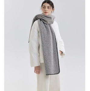 Detail of grey cashmere-like scarf with black contrast stitching and thick wool texture