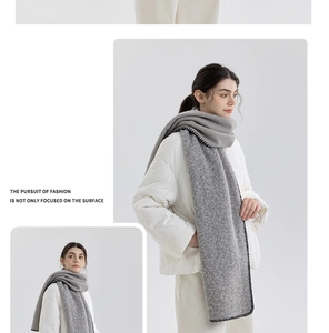 Detail of grey knitted wool scarf with black blanket-stitch edges for winter fashion