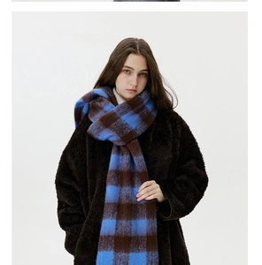 Close-up of thick plaid cashmere-like scarf with blue and brown check pattern texture