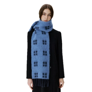 Blue and black plaid wool tassel scarf for winter warmth shown on a female model