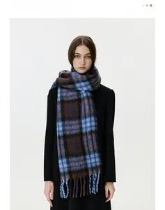 Close-up of blue and brown plaid scarf with fringe details worn over a black coat