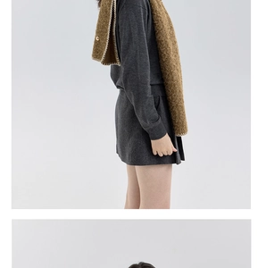Detail of grey knitted sweater with brown fleece scarf featuring gold buttons and white piping
