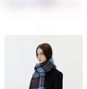 Close-up of the soft brushed texture and blue brown plaid pattern of the winter scarf