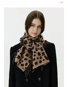 Close-up of leopard print knit scarf featuring elegant fringe tassels and thick warm fabric