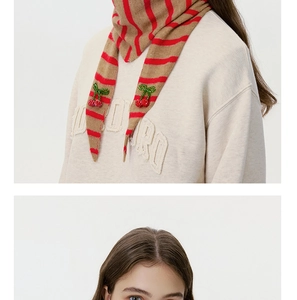 Detail of wool knit striped scarf with red cherry bead applique and retro stripes