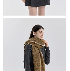 Detail of brown knit scarf with white stitched edges and soft boucle wool texture
