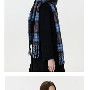Detail of blue and brown checkered scarf with fringe tassels worn over a black coat