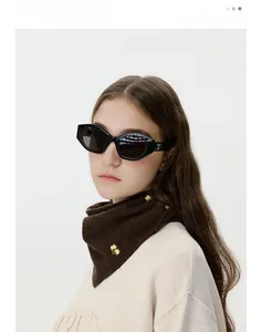 Detail of soft brown knitted triangle scarf with vintage yellow flower embroidery