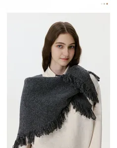 Close-up of dark grey wool knit scarf featuring dense tassel fringe and thick texture