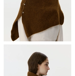 Detailed knit texture and button closure of a brown chunky knit shoulder shawl