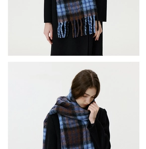 Close-up of blue and brown plaid scarf featuring soft texture and handmade tassels