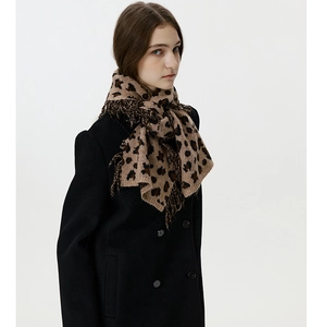 Close-up of leopard print knit scarf featuring stylish tassel trim and soft texture