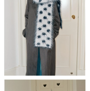 Detail of soft white knitted scarf with blue polka dots paired with a grey coat