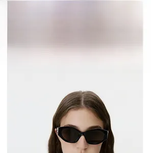 Close-up of black cat-eye sunglasses with thick frames and silver metal temple hinges