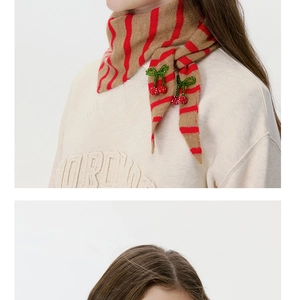 Detail of wool knit striped scarf featuring handmade beaded cherry accents on the edge