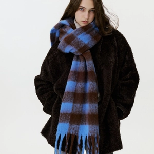 Blue and brown checkered cashmere-like scarf with tassels on a thick winter coat