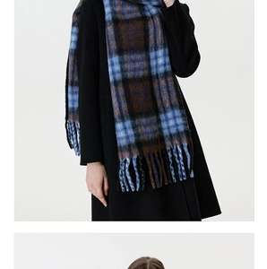 Detail of blue and brown checkered scarf with thick tassels and warm wool-like texture