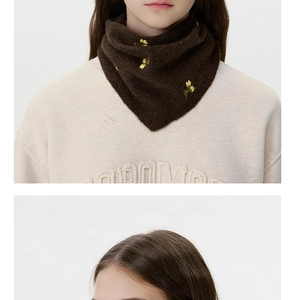 Close-up of soft brown wool knit scarf featuring delicate yellow flower embroidery details