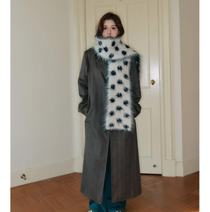 Close-up of white plush polka dot knitted scarf paired with a grey winter wool coat
