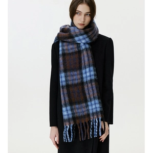 Close-up of blue and brown plaid scarf showing thick knit texture and long tassel details