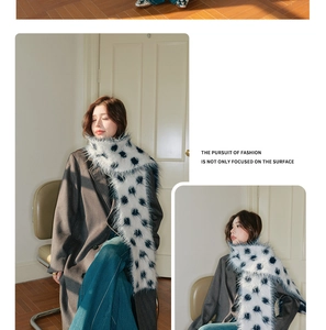 Detail view of plush black and white polka dot knit scarf with soft wool texture