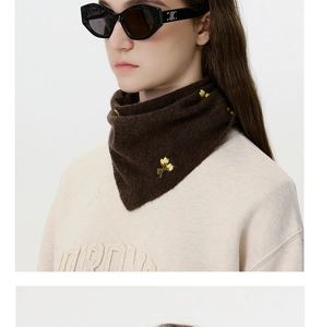 Detailed view of yellow flower embroidery on a soft dark brown knitted wool scarf