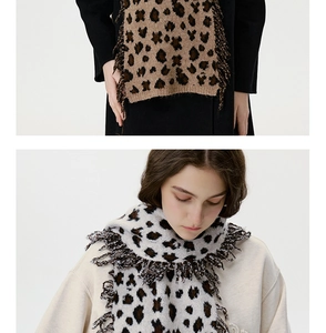 Detailed view of leopard print knit scarf with fringe edge on beige backdrop