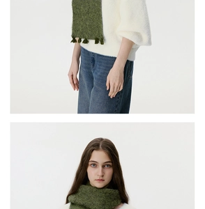 Detail of moss green knitted scarf featuring soft fuzzy texture and fringe tassels