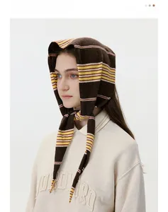 Detail showing soft striped knit fabric texture on a brown triangular headscarf