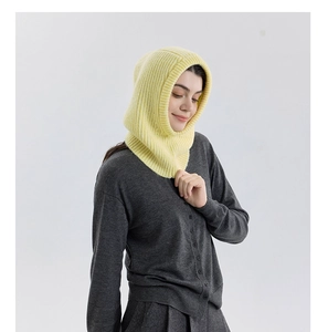 Detailed knit texture of bright yellow wool blend balaclava worn by model for winter warm