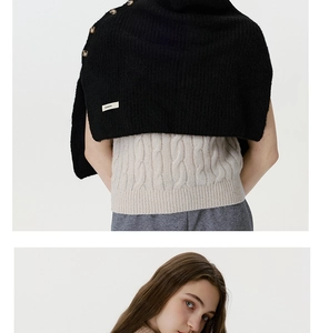 Detail view of black knitted buttoned neck warmer shawl with textured stitching and label
