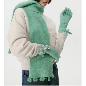 Detail of mint green wool blend knit scarf with fringe and matching bow gloves