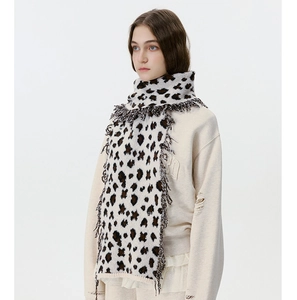 Macro detail of leopard print knitted scarf with soft fringe and warm texture