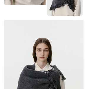 Close-up of dark grey wool knit triangle scarf featuring detailed long fringe tassels
