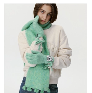 Detail of mint green wool blend knitted scarf and gloves with bow tie and logo patch