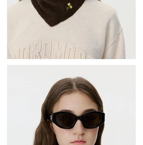 Close-up of wool knit scarf with yellow flower embroidery and chic cat-eye sunglasses