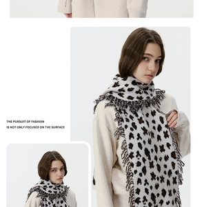 Detail view of leopard print knit scarf featuring elegant handmade tassel fringe edges
