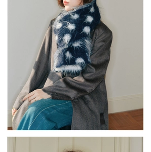 Detail of soft navy blue faux fur scarf with white polka dots worn with a wool coat