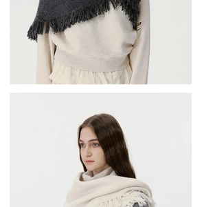 Detail of wool blend knitted triangle scarf with fringe in dark grey and beige colors