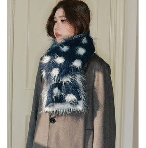 Close-up of warm navy blue wool scarf with white polka dots on a winter coat