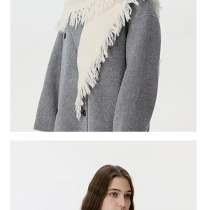 Detail showing high-quality wool blend fabric texture of grey coat and cream fringe scarf