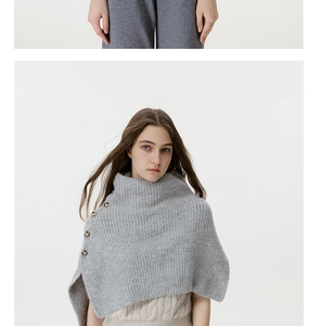 Detail view of a grey knit shawl with four vintage side buttons layered over a sweater