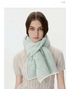 Detail of light green ribbed knit scarf showing soft wool blend texture and vertical stripes