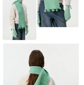 Detail of mint green wool blend knitted scarf with tassels and matching heart label gloves