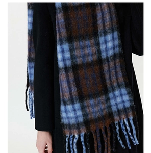 Detail of blue and brown checkered scarf with thick wool texture and tassels