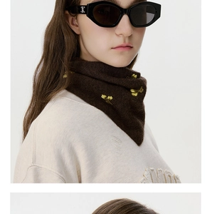 Detailed view of dark brown knitted scarf with yellow flower embroidery and chic eyewear