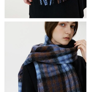 Close-up of thick blue and brown plaid scarf featuring soft brushed wool and long tassels