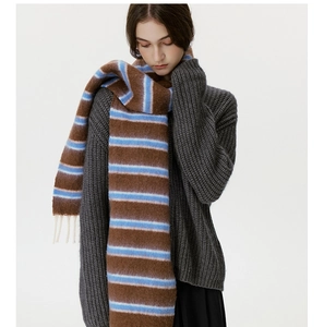 Close-up of wool blend colorful striped scarf with soft fringe tassels and knit texture