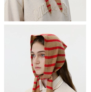 Macro detail of striped wool knit scarf texture and embroidered beige sweatshirt collar