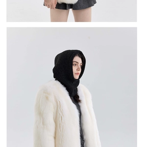 Detail of black chunky knit balaclava paired with a white faux fur coat for winter fashion